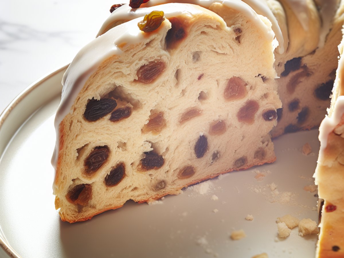 Angeschnittener Kardamom-Rosinen-Hefezopf mit sichtbarer luftiger Krume und eingebackenen Rosinen